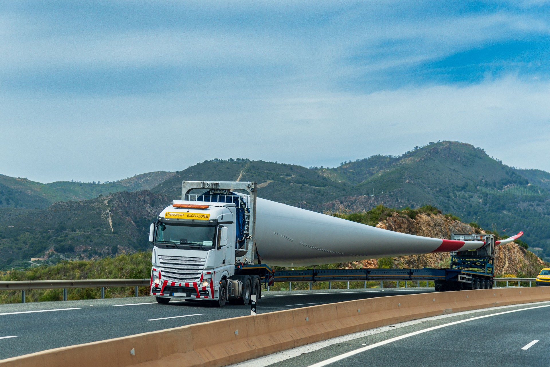 Truck for oversized or special transport carrying a wind turbine blade, driving on a highway